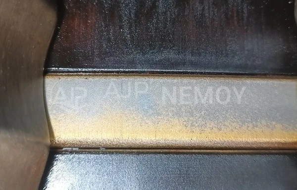 Detailed photograph of the first piston ring and the adjacent piston surfaces.